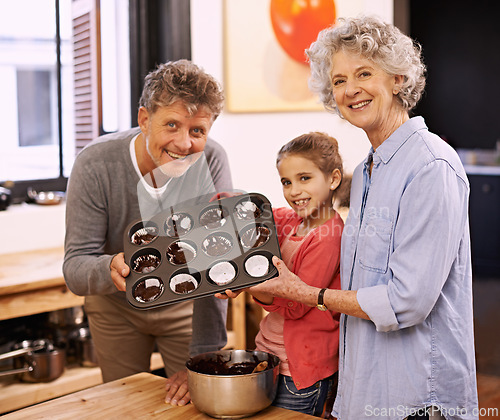 Image of Girl, grandparents and portrait with cupcakes, kitchen and baking together. Mature couple, smile and child for happiness, love and learning at home with grandmother for childhood memories and family