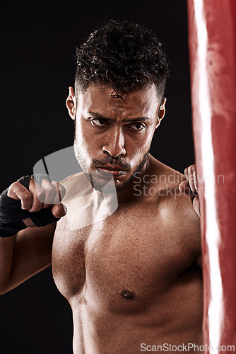 Image of Boxing, man and training in studio with fitness for workout, exercise or competition fight with punching bag. Athlete, boxer and confidence for martial arts with energy or topless on black background