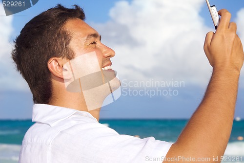 Image of happy man with phone on the beach