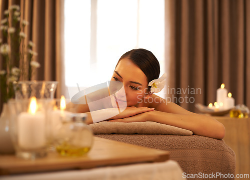 Image of Woman, smile and relax with candle at spa for aromatherapy, stress and relief and holistic massage. Asian person, peace and zen at luxury hotel for self care, body health and spiritual healing