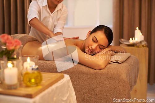 Image of Back massage, therapist and woman relax in spa for skincare, wellness or health at table for luxury. Body, pamper or hands of masseuse at salon for beauty, peace or calm with candles for aromatherapy