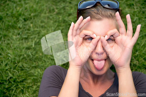 Image of Portrait, hand glasses and woman with tongue out for funny face, goofy or silly in outdoor garden. Top view, comic and female person joking for humor, finger shape gesture and playful mood in park