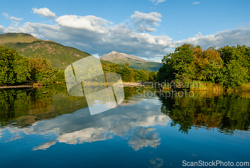 Image of Majestic mountains reflecting in serene lake on a sunny afternoo