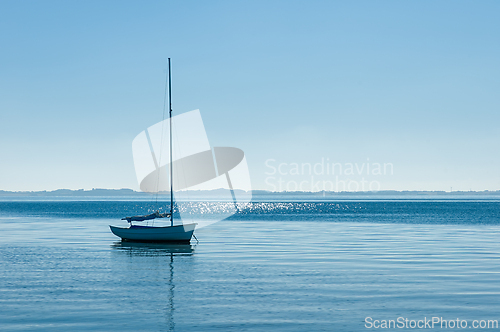 Image of Serene sailboat on tranquil waters under clear blue skies at dus