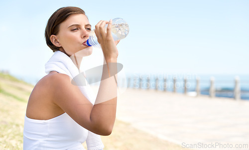 Image of Woman, drink water and outdoor at beach for health, fresh air and fitness in nature, h2o and sea. Nutrition, detox and mineral liquid for thirst, hydration and exercise with beverage for wellness