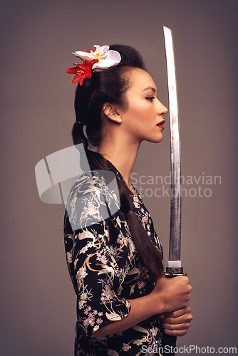 Image of Japanese woman, fashion and sword with confidence in studio on brown background in traditional style and elegant. Asian, culture and female person with designer clothes or outfit for heritage