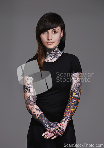 Image of Woman, portrait and tattoo with fashion or sleeves for facial treatment, style or body art on a gray studio background. Female person, young model or smile in design, creativity or cool beauty artist