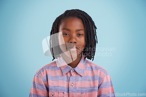 Image of African teenager, face and fashion in studio with creative, style and confidence on a blue background. Portrait of young and cool model, student or boy in natural hair and casual or trendy clothes