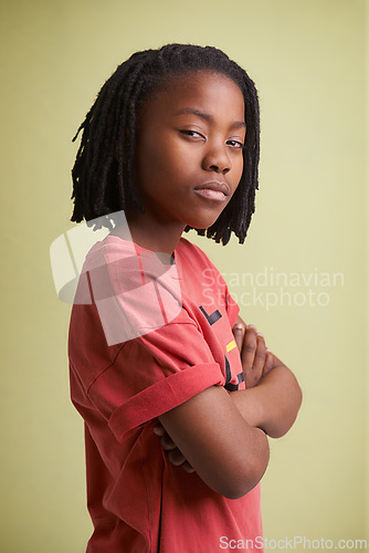 Image of Fashion, children and portrait of black boy in studio with arms crossed in confidence on green background. Mockup, face and African teen model pose with attitude, style or cool outfit choice