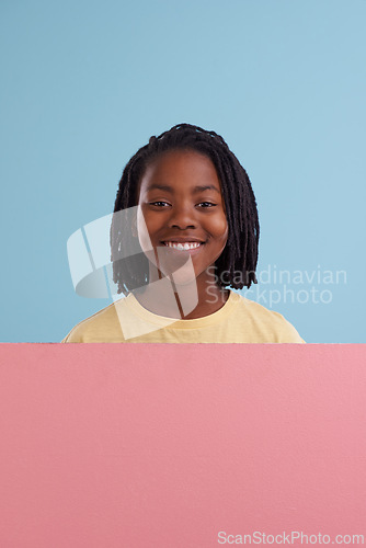 Image of Portrait, banner or happy boy child with mockup in studio for announcement, offer or info on blue background. Poster, face or teen model smile with billboard presentation for news, promo and opinion