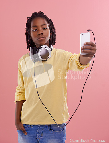 Image of Teen, boy and selfie of student in studio with headphones for listening to music and post on social media. High school, kid and live streaming on blog with pride and confidence in profile picture