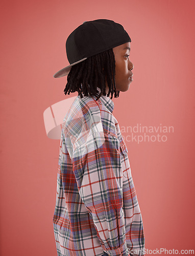 Image of Boy, fashion or black child with cap in studio for confidence, style or streetwear aesthetic on red background. Face, profile or African teen male model with cool, clothes or trendy outfit choice