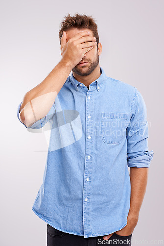 Image of Regret, stress and face palm with man in studio for embarrassment, thinking and headache. Sad, shame and tired male person with anxiety, fatigue and bad memory on white background with hand on head