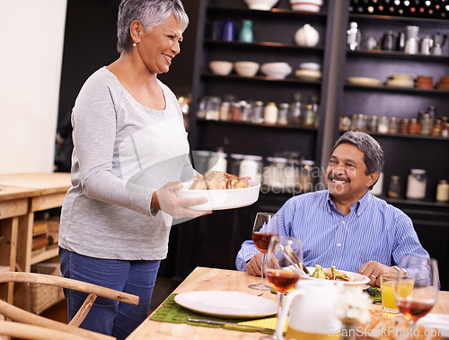 Image of Senior, happy woman and family with turkey for thanksgiving dinner, meal or food at the table. Mature and hungry couple with smile for dining, eating or lunch in happiness together at the house