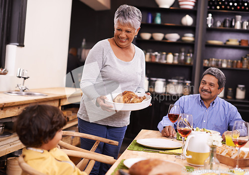 Image of Happy, big family and turkey with child for thanksgiving dinner, meal or food at the table. Grandparents, little boy or child with smile for dining, eating or lunch in happiness together at the house