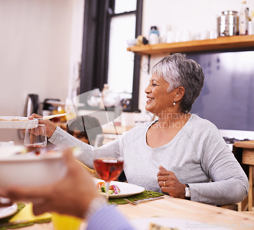 Image of Mature, happy woman and family with food for thanksgiving dinner, meal or serving at the table. Senior and hungry grandmother with smile for dining, eating or lunch in happiness together at the house