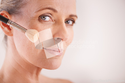 Image of Brush, beauty and portrait of woman in studio for cosmetic, self care and facial glow routine. Makeup, foundation and mature person with cosmetology tool for treatment by white background with mockup