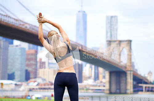 Image of Woman, stretching back for workout in city for fitness or exercise, physical health and stress relief. Girl active to warm up muscle, cardio and training for sports runner or athlete in New York.