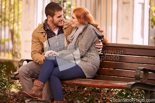 Image of Couple, love and sitting with hug at park in cold weather or winter, together and smile in London. Relationship, commitment and bonding for romance with soulmate, care and happiness on holiday