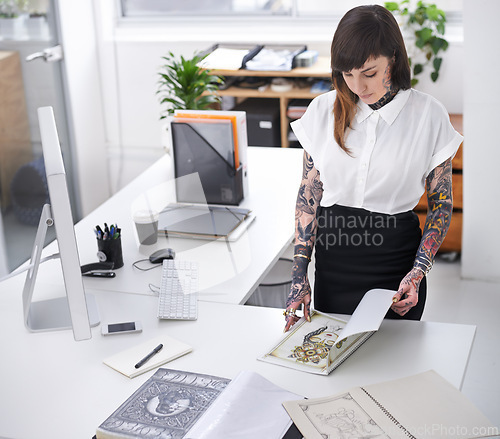 Image of Tattoo, woman and book in office for business with creative planning, design choice and sketch in folder. Entrepreneur, artist and ring binder with inspiration for body art and work project at desk