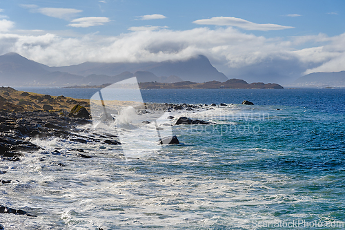 Image of Majestic waves crashing onto rocky shoreline of a remote coast o