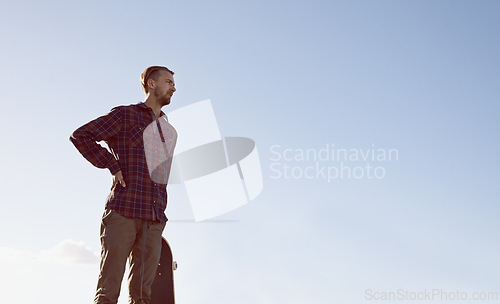 Image of Skateboard, thinking and man at a skate park with idea for trick, stunt or adrenaline sports on blue sky background. Planning, calm and male skateboarder with reflection, questions or memory on ramp