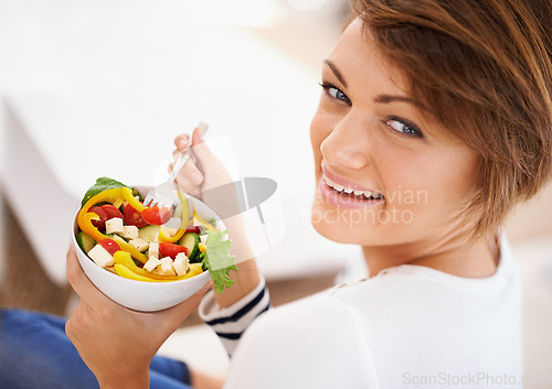 Image of Woman, salad and happy portrait with eating food for diet, detox and breakfast on sofa at home. Person relax and healthy vegetables, tomato and green or vegan meal in bowl for nutrition and wellness