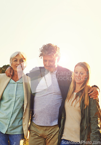 Image of Sunset, nature and senior parents with daughter for adventure, hiking and walking outdoors. Family, travel and mature mother, father and woman embrace on holiday, vacation and weekend together