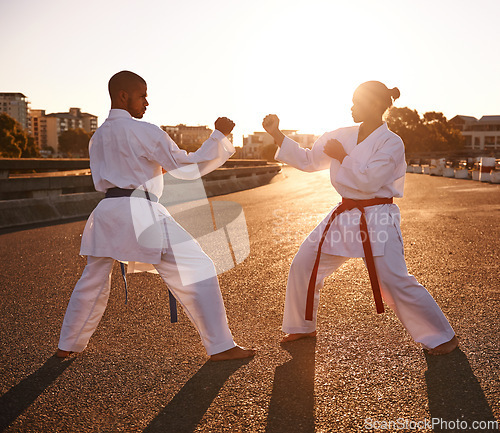 Image of People, karate and fighting with personal trainer for self defense, technique or style in city street. Man and woman fighter or athlete in fitness training, martial arts or kick boxing in urban town