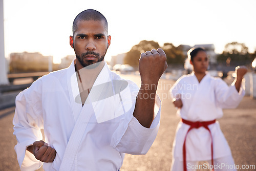 Image of Serious people, karate and martial arts with personal trainer for self defense, class or teaching in city street. Man and woman fighter or athlete in fitness training, kata or technique in urban town