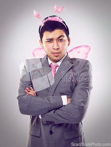 Image of Studio, portrait and man as fairy for magic in Halloween party of startup up business and company. Adult, guy and male person with professional suit, costume and frown on face with arms crossed