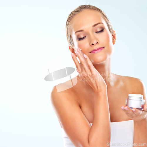 Image of Mockup, woman and portrait with skincare cream for self care, cosmetics and application in studio. Female person, satisfaction and facial product with beauty, lotion and glow on blue background