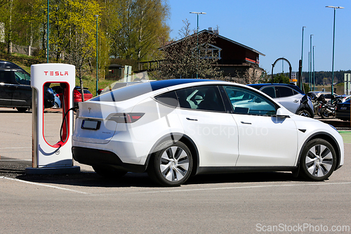Image of White Tesla Model Y Electric Car Charging Battery