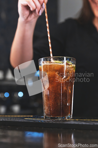 Image of Close-up of a hand stirring a refreshing glass
