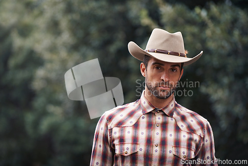 Image of Man, portrait and outdoor cowboy fashion, western culture and countryside ranch in Texas. Male person, hat and flannel shirt for farmer aesthetic, nature and plaid style by trees or outside bush