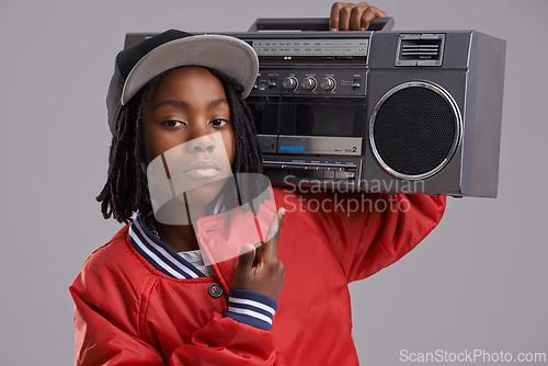 Image of Black child, serious and portrait with radio and hand sign for hip hop, rap and swag with cool clothes in studio. Young, teen and boombox with gangster style and fashion and kid with grey background