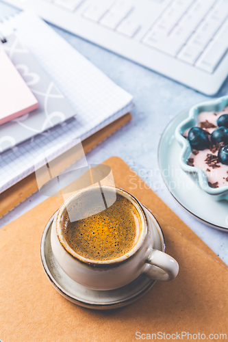 Image of Coffee break in a office, cup of coffee with healthy yogurt in a office. 