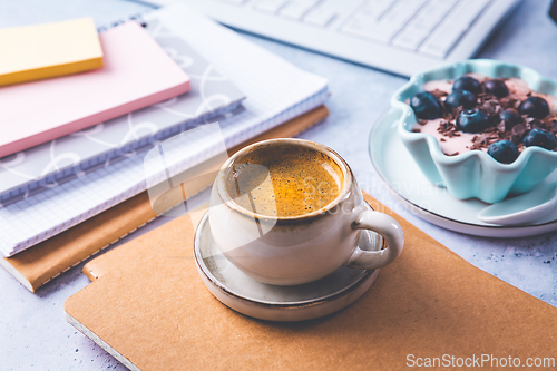 Image of Coffee break in a office, cup of coffee with healthy yogurt in a office. 