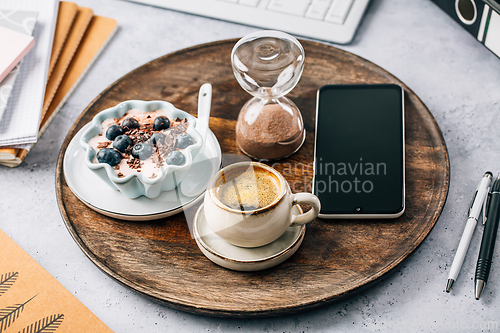 Image of Coffee break in a office, cup of coffee with healthy yogurt in a office. 