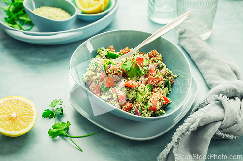 Image of Tabbouleh salad. Fresh homemade Tabouli salad with fresh parsley, onions, tomatoes and hempseeds