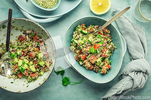 Image of Tabbouleh salad. Fresh homemade Tabouli salad with fresh parsley, onions, tomatoes and hempseeds