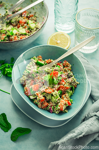 Image of Tabbouleh salad. Fresh homemade Tabouli salad with fresh parsley, onions, tomatoes and hempseeds