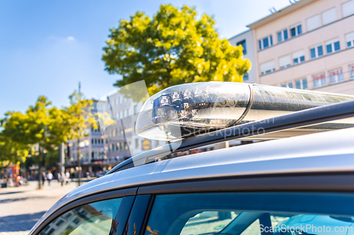 Image of Detail of German police car with blue light  in a city
