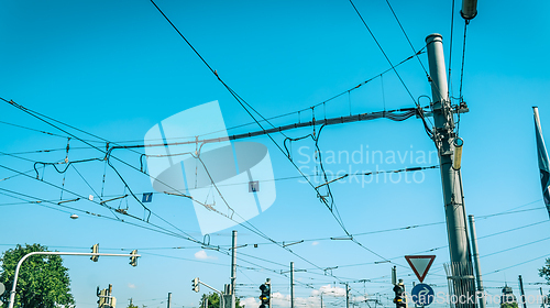 Image of Electric wiring of city tram and bus traffic against blue sky