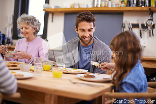 Image of Love, breakfast and family in a kitchen with pancakes, eating or bonding at a table together. Food, diet and girl with father, grandmother and waffle for brunch, nutrition or communication at home