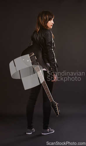 Image of Woman, guitar and fashion for musical instrument, sound and trendy for retro and style on dark background. Young person, musician and artist for creative, funky and edgy for bold with leather jacket