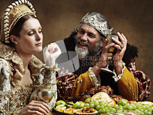 Image of King, queen and royalty with feast and wine in banquet hall for fine dinning for tradition or culture in palace. Monarch, sovereign and together with buffet for luxury, bored and vintage with goblet.