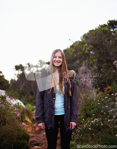 Image of Woman, smile and portrait for hiking and adventure in nature with trail for walking outdoor for exercise. Young person and with backpack and happy for holiday in landscape with bush and path