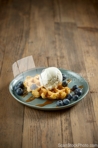 Image of plate of belgian waffle with caramel sauce and blueberries