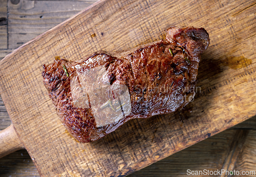Image of fresh grilled beef steak meat with salt and pepper on wooden cut